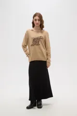 Sweater de tejido de punto color beige con estampado jacquard de leopardo en color negro. Presenta cuello redondo amplio y puños y ruedo acanalados.
