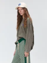 Remera de manga larga con calce holgado y cuello a la base. Presenta un diseño minimalista con una pequeña estrella estampada en el pecho y gráficos inspirados en el universo tora en la parte posterior. Confeccionada en algodón con acabado tipo gastado.