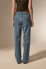 Pantalon de jean azul de corte recto y calce medio, con bordados de estrellas y detalles de pequeñas tachas.