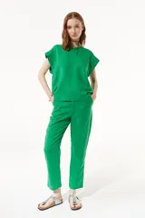 Pantalón chino verde confeccionado en lino y viscosa, de tiro medio-alto y pierna recta. Cuenta con bolsillos laterales y traseros.