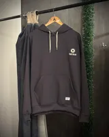 Canguro oversized color negro con estampado frontal en blanco que incluye dos soles y el texto "TRIBU BRAND".