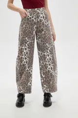 Pantalon tipo jean de corte barrel y tiro bajo, con estampado animal print de leopardo en tonos marrones y blancos.