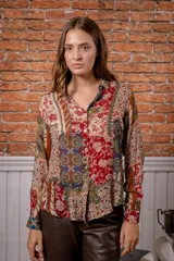 Camisa de manga larga con estampado de leopardo, cuello clásico y cierre frontal de botones. Presenta un corte holgado y puños abotonados.