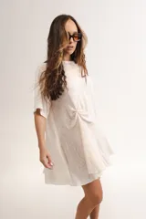 Vestido corto color crema, de corte suelto y manga corta, con detalle de nudo en la parte delantera.