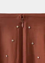 Falda midi de tiro alto con diseño recto, confeccionada en lyocell y poliéster color marrón, adornada con aplicaciones de strass y abertura posterior en el bajo.