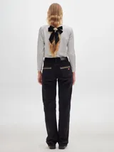 Remera de manga larga con cuello redondo y estampado a rayas horizontales en tonos marrón y negro. Tiene un logo bordado en el pecho de color rojo.