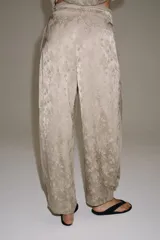 Pantalón de tiro medio de ZARA WOMAN COLLECTION, confeccionado en hilatura de viscosa con tejido jacquard de estampado floral sutil en tono beige. Presenta pierna ancha, acabado en pliegue y cintura ajustable con cordón de lazada.