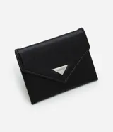 Billetera femenina tipo sobre, color negro, confeccionada en poliuretano con acabado en caseína. Presenta un recorte triangular en la tapa delantera, cierre con botón a presión y una placa metálica triangular con el logo de Satinato.