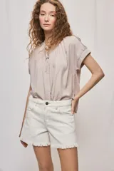 Short de jean blanco de tiro medio con silueta relajada y detalle de ruedo desflecado con flecos.