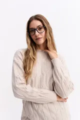 Buzo de punto color celeste con diseño de trenzas en relieve, cuello redondo y mangas largas con puños acanalados.