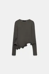 Jersey de punto gris oscuro con cuello redondo y manga larga, con bajo asimétrico acabado en volante con varilla metálica interior.