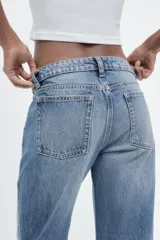 Pantalón de jean negro de corte recto y tiro bajo, con trabillas y cinco bolsillos.