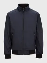 Campera bomber azul marino de poliéster con cuello alto, cierre frontal con cremallera, puños y dobladillo elásticos, dos bolsillos laterales con cremallera y un bolsillo pequeño con cremallera en la manga izquierda.