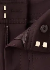 Pantalón de vestir marrón oscuro, de tiro medio y corte recto, con bolsillos frontales tipo parche decorados con botones metálicos dorados.