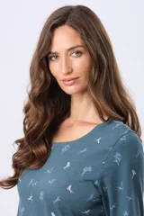 Remera de manga larga con cuello redondo, confeccionada en tejido de algodón estampado con motivos botánicos y aves pequeñas en tonos suaves.