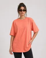 Remerón de corte oversize color coral, con cuello redondo y mangas cortas, confeccionado en algodón.