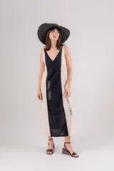 Vestido largo de lino con diseño bicolor en beige y crudo, escote en V y breteles regulables. Presenta detalles de bordados geométricos en el frente y tajos laterales.