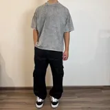 Pantalón jean cargo gris con efecto lavado, corte recto y bolsillos laterales.