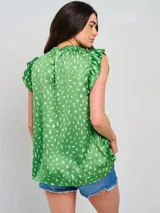 Blusa sin mangas color verde con estampado abstracto en blanco, cuello redondo fruncido y volados en los hombros.