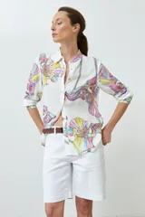 Camisa blanca con estampado de lirios de campo en tonos fucsia, amarillo y celeste.