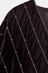 Kimono abierto de manga larga confeccionado en tejido de terciopelo acolchado. Presenta un diseño con costuras diagonales decoradas con hilo metalizado y aplicación de abalorios.
