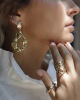 Anillo ancho de diseño orgánico y calado, con apariencia de red o magma solidificado.