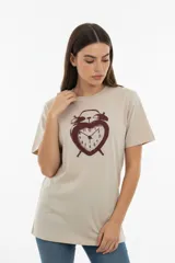 Remera de algodón color beige, de corte holgado y manga corta, con estampado frontal de un reloj despertador en forma de corazón.
