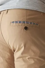 Pantalón chino clásico color ladrillo, de corte slim, con presillas para cinturón.