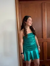 Vestido corto con estampado de rayas horizontales en tonos grises y negros. Diseño con escote halter que se ata al cuello, abertura central en el busto y falda corta con volado.