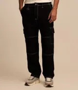 Pantalón masculino modelo baggy confeccionado en sarga de algodón, con cintura con trabillas, bolsillos cargo laterales y costuras con pespuntes en contraste.