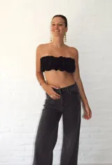 Top bandeau negro con textura fruncida y estampado abstracto plateado.