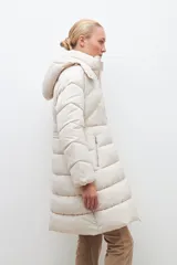 Campera puffer de corte largo y diseño capitoneado, con capucha desmontable y cierre frontal completo. Presenta bolsillos laterales con cierre y puños elásticos.