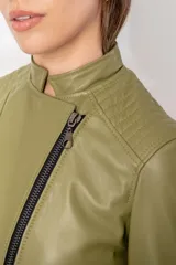 Chaqueta de cuero ovino estilo motoquera, color verde oliva, con cierre frontal cruzado, bolsillos horizontales con cierre y detalles de acolchado en hombros y codos.