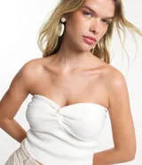 Top cropped de punto color blanco, sin breteles y con detalle retorcido en el busto.