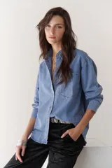 Camisa de jean celeste de manga larga con botones frontales y en los puños.