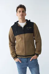 Campera de felpa gris con capucha y cordón ajustable, cierre frontal con cremallera, bolsillos laterales, mangas largas y logo estampado en el pecho.