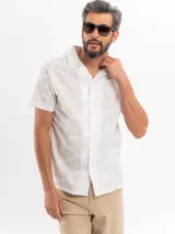 Camisa de manga corta de algodón en color beige, con cuello camisero y cierre frontal de botones, con diseño estampado sutil.