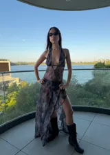 Vestido largo de tul con estampado tie-dye en tonos negro y gris, con escote halter profundo y falda con tajo lateral.