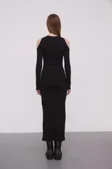 Vestido midi negro de punto canalé con mangas largas y hombros descubiertos.