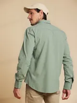 Camisa de manga larga color verde claro, con cuello clásico y cierre frontal con botones.