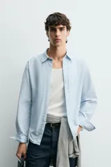 Camisa regular fit de color celeste, confeccionada en tejido con mezcla de algodón y seda, con cuello solapa, manga larga con puño abotonado y cierre frontal de botonadura.