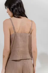 Top negro con rayas verticales blancas, escote en V y breteles finos regulables con detalle de borlas.