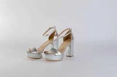 Sandalias negras de cuero con plataforma y tacón cuadrado. Tira delgada sobre los dedos y pulsera tobillera con hebilla dorada.