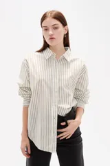 Camisa de algodón con diseño de rayas verticales finas en tonos neutros, corte holgado, cuello camisero y cierre frontal con botones.