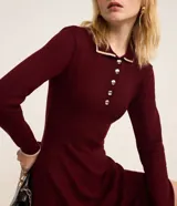 Vestido corto de punto color borgoña, con cuello polo blanco abotonado y mangas largas.