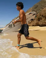 Boardshort de baño negro con paneles laterales grises y diseño estampado geométrico en forma de rombo con llamas. Cuenta con cintura fija y cordón ajustable.