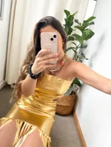 Vestido dorado de fiesta, strapless, con abertura en la cintura y falda midi con flecos.