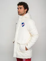 Parka larga de abrigo color azul marino, con capucha, cierre frontal, bolsillos con solapa y bolsillo superior con cierre. Presenta el logo de Umbro y el escudo del Club Nacional de Football.