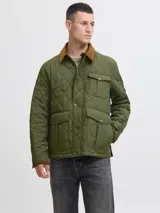 Campera acolchada de diseño matelaseado en color verde oliva, con cuello camisero en pana marrón, cierre frontal con botones a presión y bolsillos frontales con solapa.