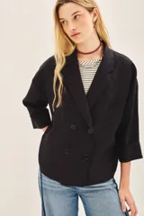 Saco corto de lino con corte oversize y mangas amplias. Presenta un diseño de doble abotonadura frontal y forro interior de lino.